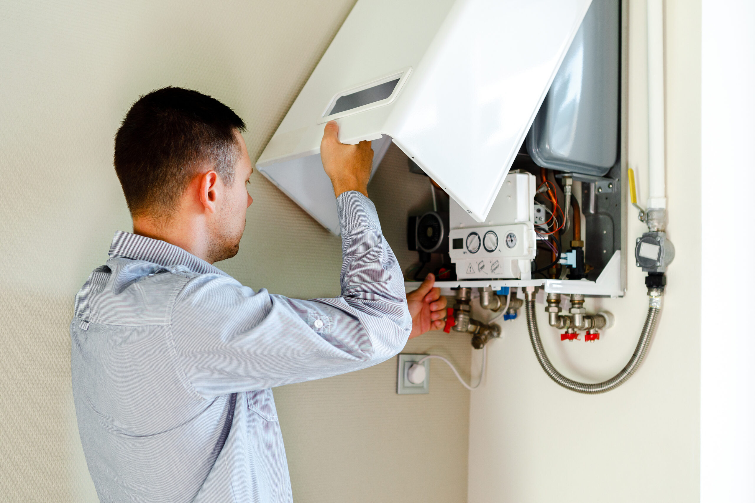 Technician servicing a modern tankless water heater, Bucky's Water Heaters Now installation and repair experts in Calgary