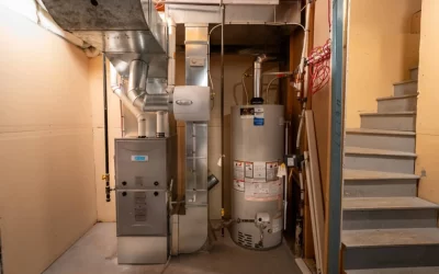 Basement utility room with a furnace, HVAC ductwork, and water heater next to a staircase.
